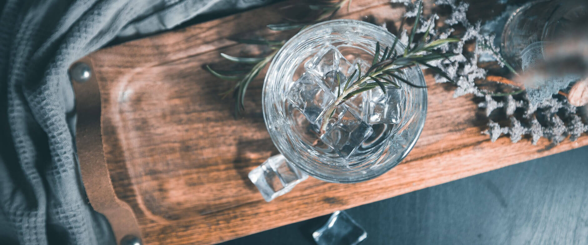 Glas mit Gin Tonic und Eiswürfeln von oben