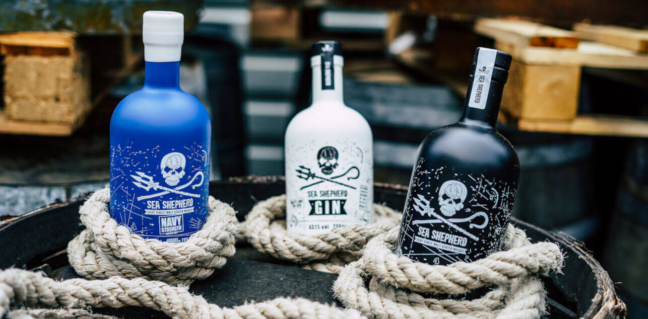 Entdecke die Sea Shepherd Produkte Eine schwarze, weißeund blaue Flasche zwischen weißem Tampen