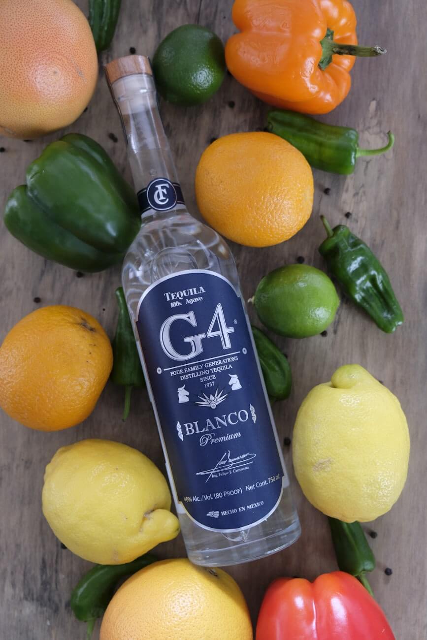 G4 Tequila Blanco mit gelber roter und grüner Paprika, Zitronen auf einem Brett