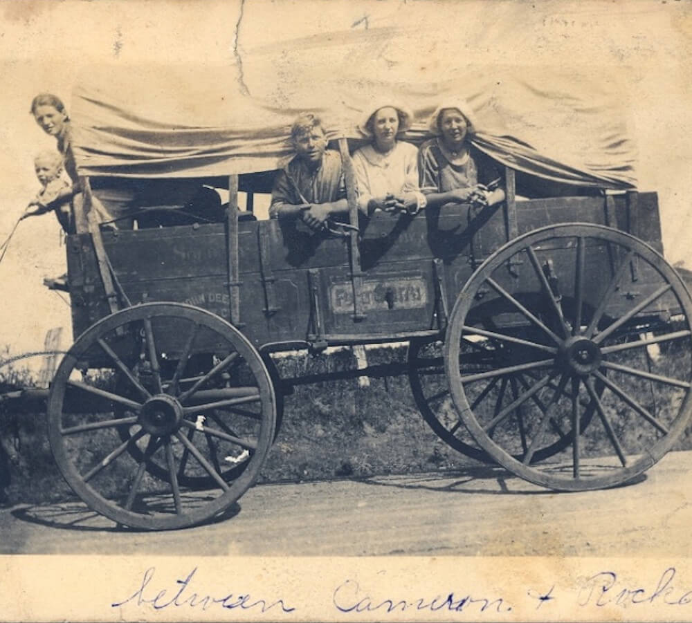 Planwagen ein alter Planwagen aus den USA mit KIndern die seitlich herausschauen
